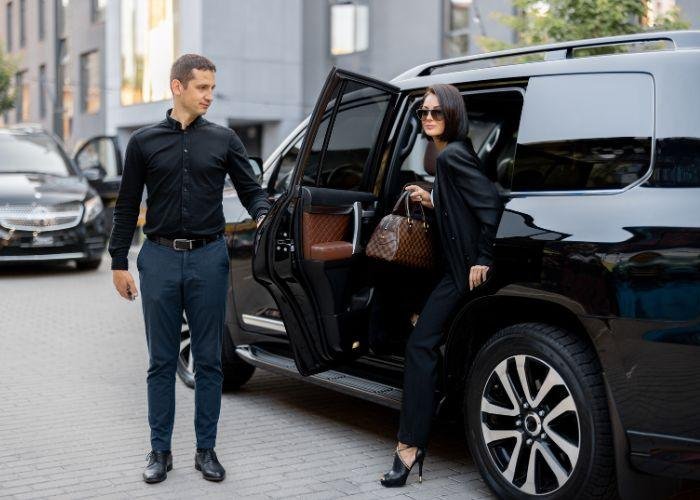 Corporate chauffeur hire Sydney - Chauffeur Driver open the door of the SUV